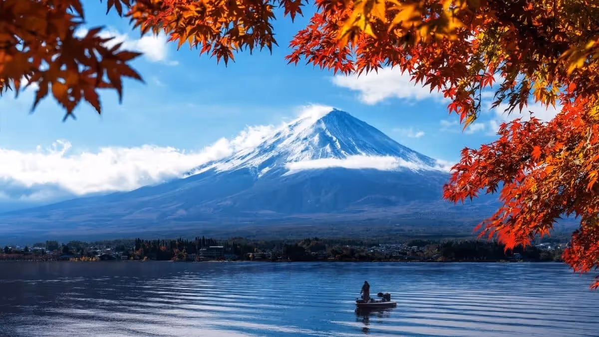 Vue du mont Fuji au bord du lac encadrée de feuilles d’érables rouges et orangées en automne