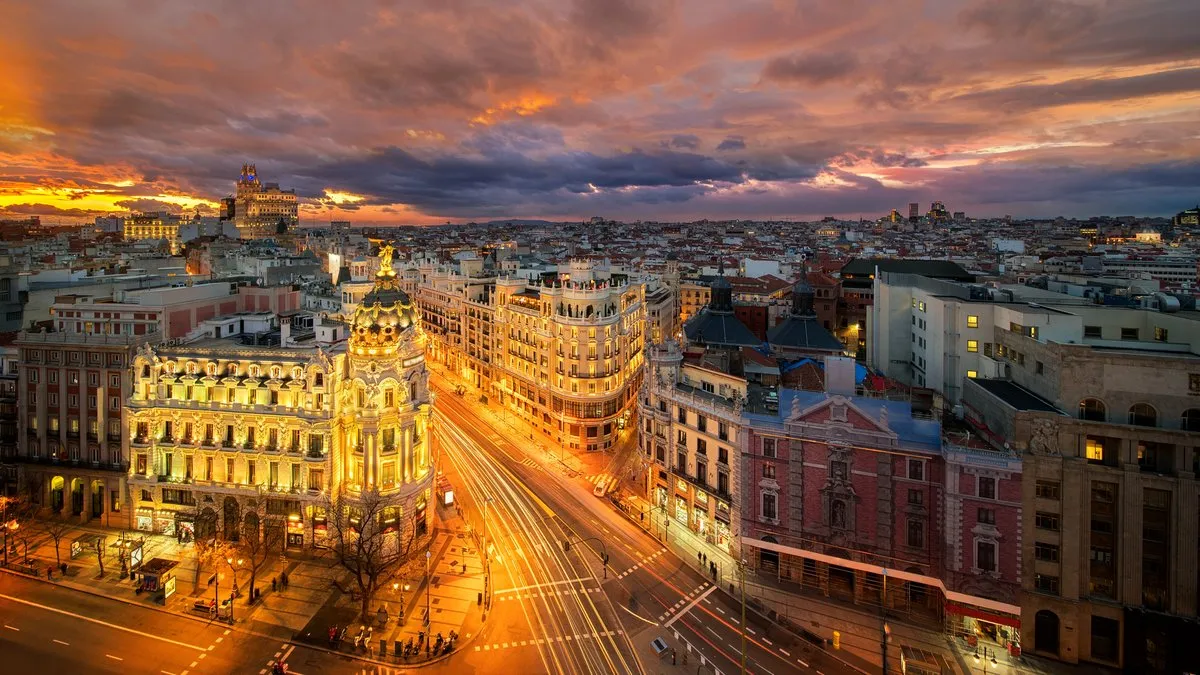 Vue panoramique du centre-ville de Madrid illuminé au coucher du soleil, avec la Gran Vía en perspective.