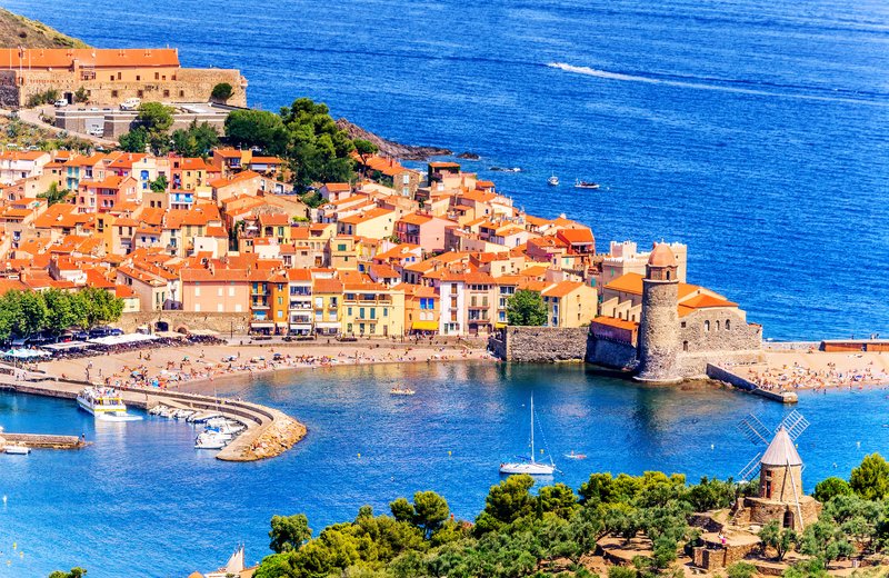 Vue panoramique de Collioure sur la Côte Vermeille avec ses maisons colorées, son clocher emblématique et le bord de mer méditerranéen.