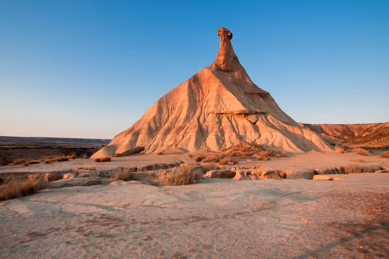 Formation rocheuse emblématique en forme de cheminée de fée dans le désert des Bardenas Reales au coucher du soleil.