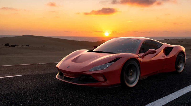 Ferrari F8 Tributo rouge roulant sur une route au coucher du soleil dans un décor désertique.