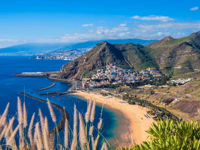 lage de sable doré et village côtier entourés de montagnes à Tenerife, îles Canaries.