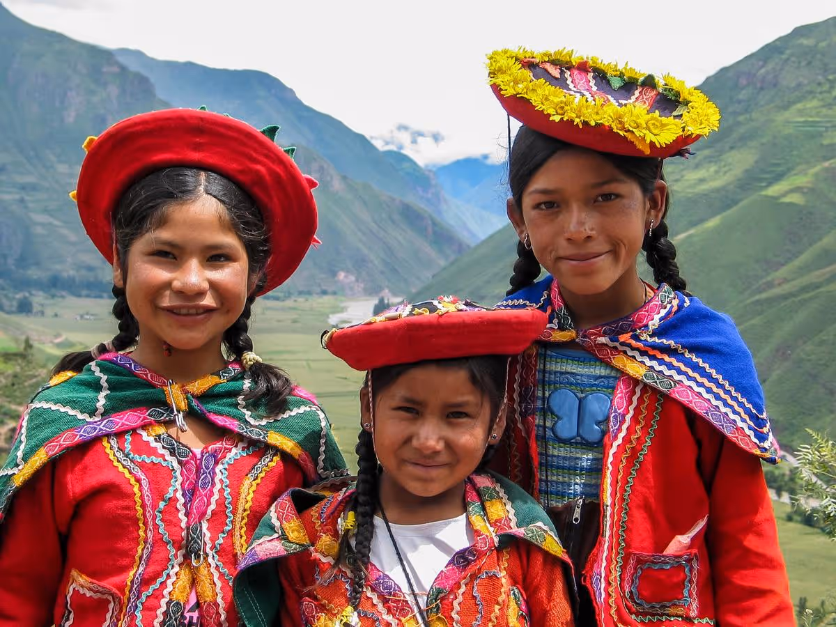 Trois enfants en habits traditionnels andins dans la vallée sacrée du Pérou