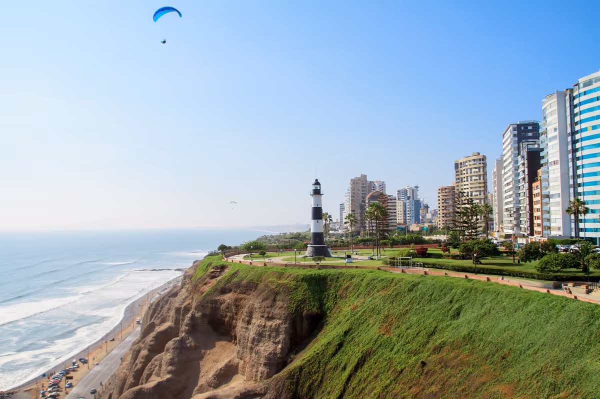 Parapente au-dessus du phare de Miraflores à Lima avec vue sur l’océan Pacifique et les falaises verdoyantes