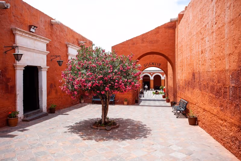 Cour intérieure fleurie aux murs rouges du monastère de Santa Catalina à Arequipa.