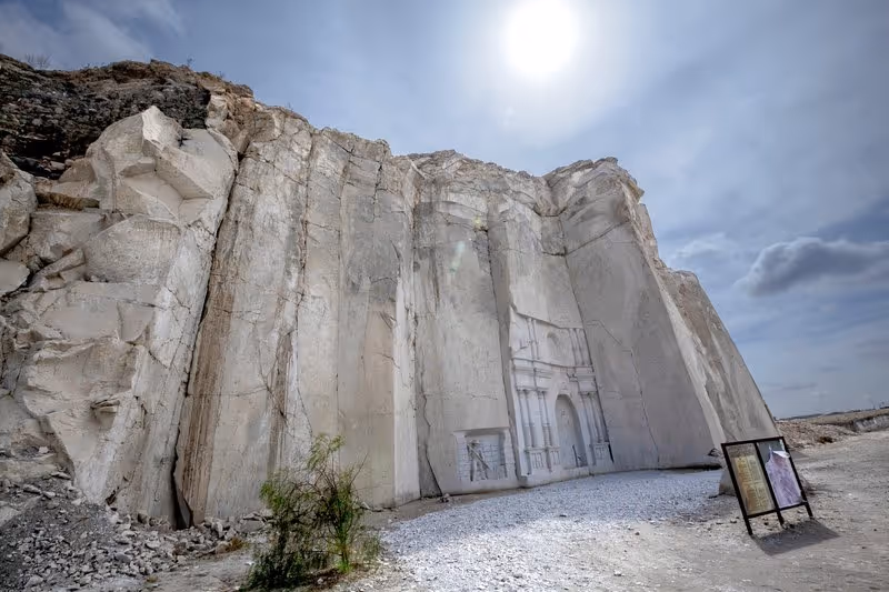 Carrière de sillar près d’Arequipa avec une façade sculptée dans la roche volcanique sous un ciel ensoleillé.