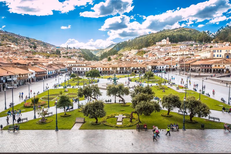Place principale Plaza de Armas de Cusco, avec jardins, fontaine centrale, bâtiments coloniaux et collines en arrière-plan