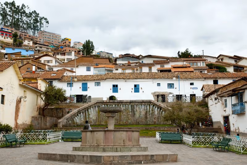 Maisons blanches aux toits en tuiles rouges dans le quartier artistique de San Blas à Cusco, avec une petite place centrale