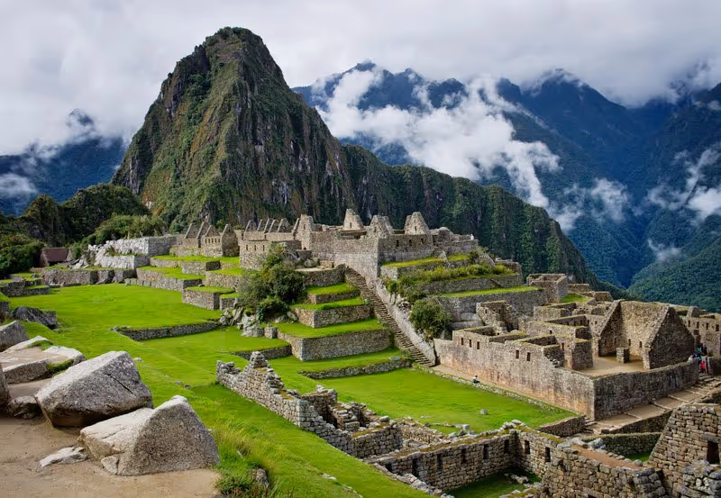 Panorama du Machu Picchu, ancienne cité inca entourée de montagnes et de nuages, site emblématique du Pérou classé UNESCO