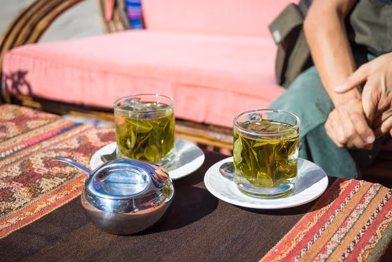 Tasses de thé de coca traditionnel sur une table andine