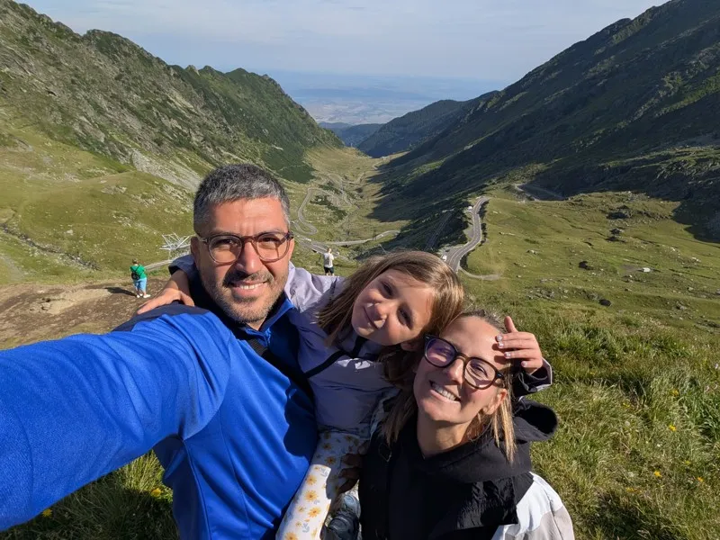 Famille souriante en montagne sur la route Transfagarasan en Roumanie, idéale pour un road trip panoramique.
