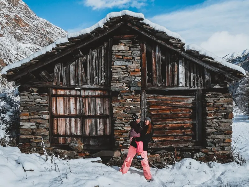 Cabane en bois enneigée dans les montagnes d’Aoste, parfaite pour un séjour nature en hiver.