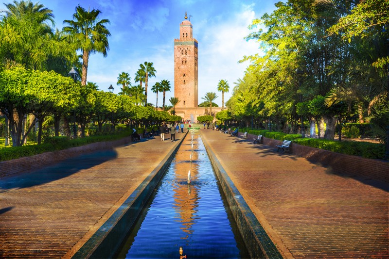 Vue de la Koutoubia et de son allée bordée de palmiers à Marrakech, Maroc.