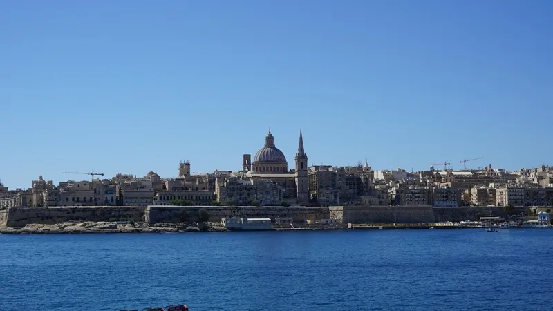 Vue panoramique de La Valette à Malte avec ses bâtiments historiques et le dôme emblématique, vue depuis la mer.