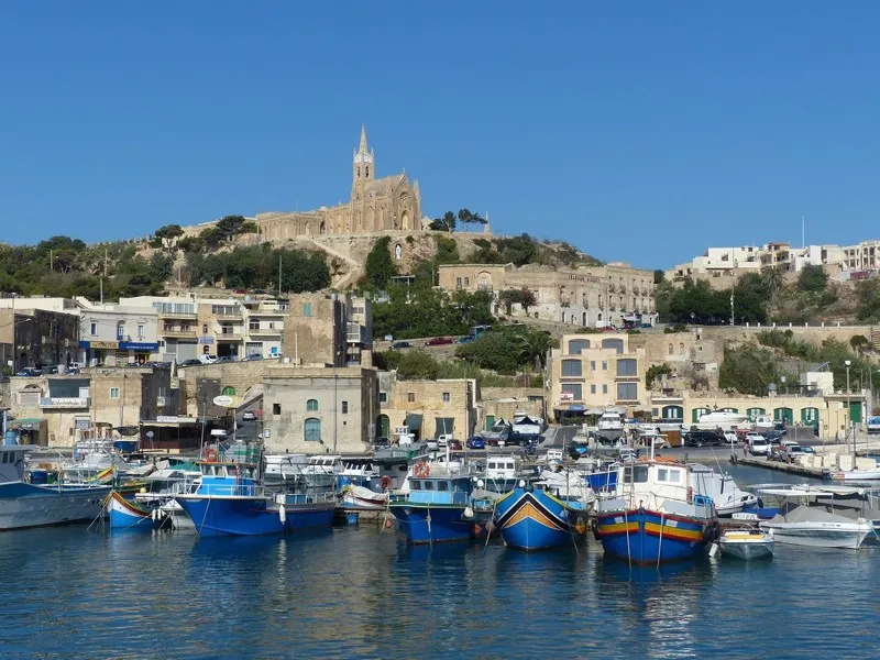 Port de Gozo avec ses bateaux colorés et l’église perchée sur la colline.