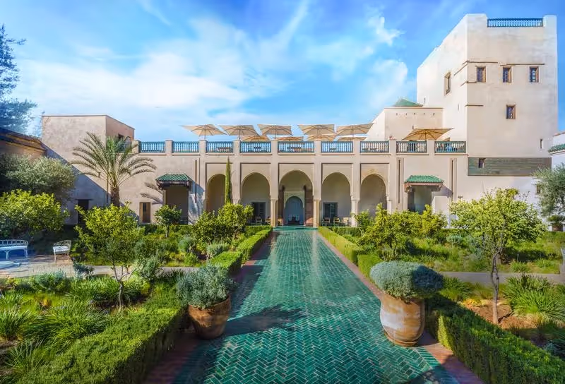 Riad traditionnel de Marrakech avec jardin luxuriant et architecture marocaine typique