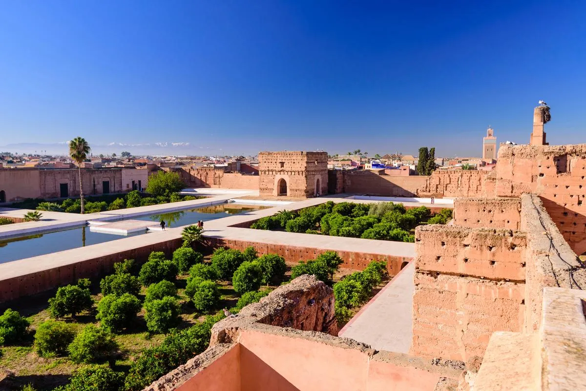 Vue panoramique du Palais El Badi à Marrakech avec ses jardins d’orangers et ses ruines historiques sous un ciel bleu limpide