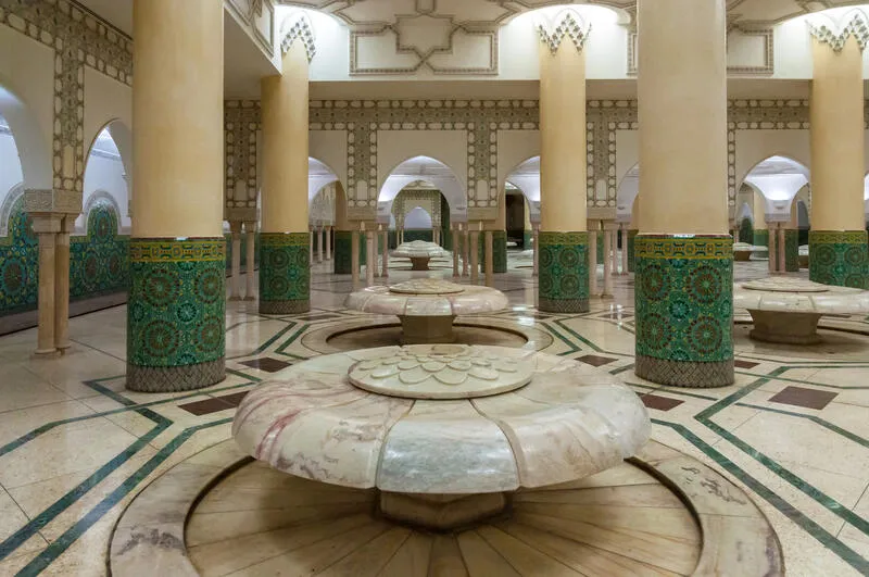Intérieur d'un hammam traditionnel marocain avec colonnes et fontaines à Fès
