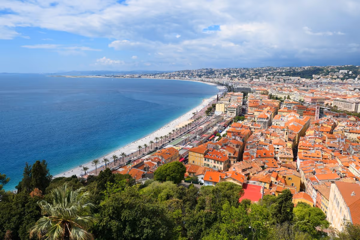 Vue panoramique de la Baie des Anges à Nice avec la promenade, les toits du Vieux-Nice et la mer Méditerranée.