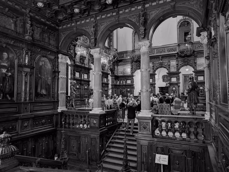 Salle intérieure du château de Peleș, décor sculpté en bois et peintures historiques.