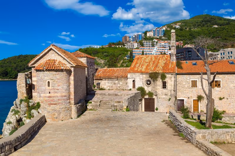 Citadelle de Budva et remparts en pierre avec toits rouges et mer Adriatique