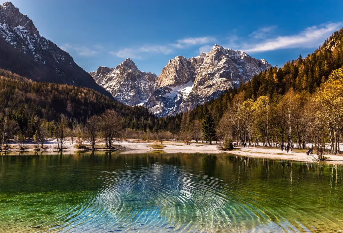 Lac Jasna aux eaux turquoise cristallines face aux sommets enneigés des Alpes juliennes dans le parc national du Triglav, Slovénie