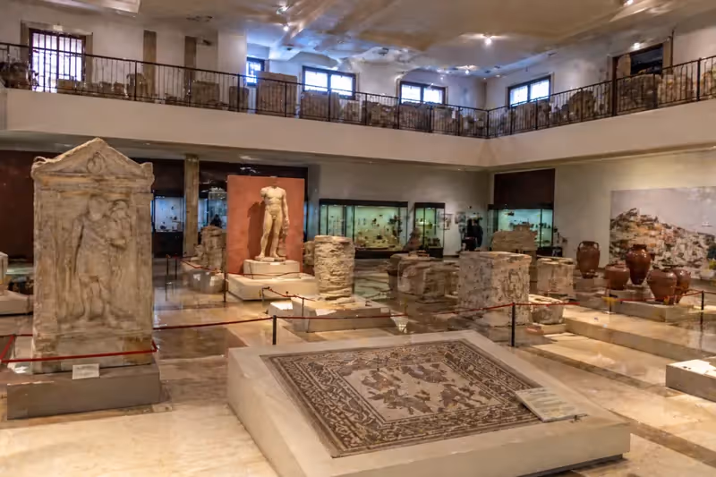 Salle du musée archéologique de Durrës avec mosaïques, statues antiques et vestiges gréco-byzantins exposés.