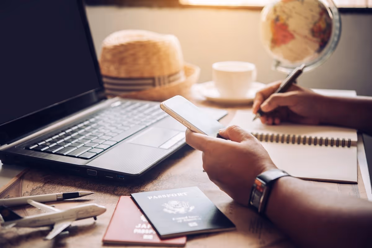 Planification d'un voyage au Canada sur mesure : passeports, carnet de notes et smartphone sur un bureau de voyageur