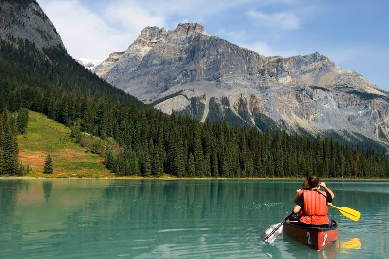 Canoë sur un lac turquoise au pied des Rocheuses canadiennes dans le parc national de Banff — activité de plein air sur mesure