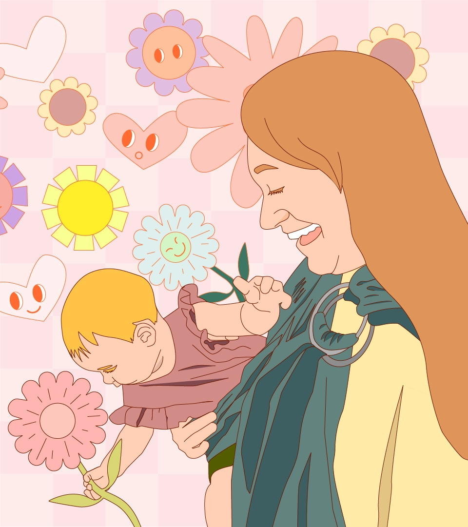 A mom holding a baby with flowers behind
