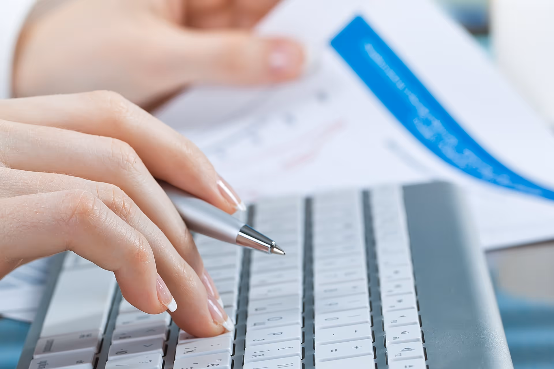 Woman hand holding a paper and a laptop