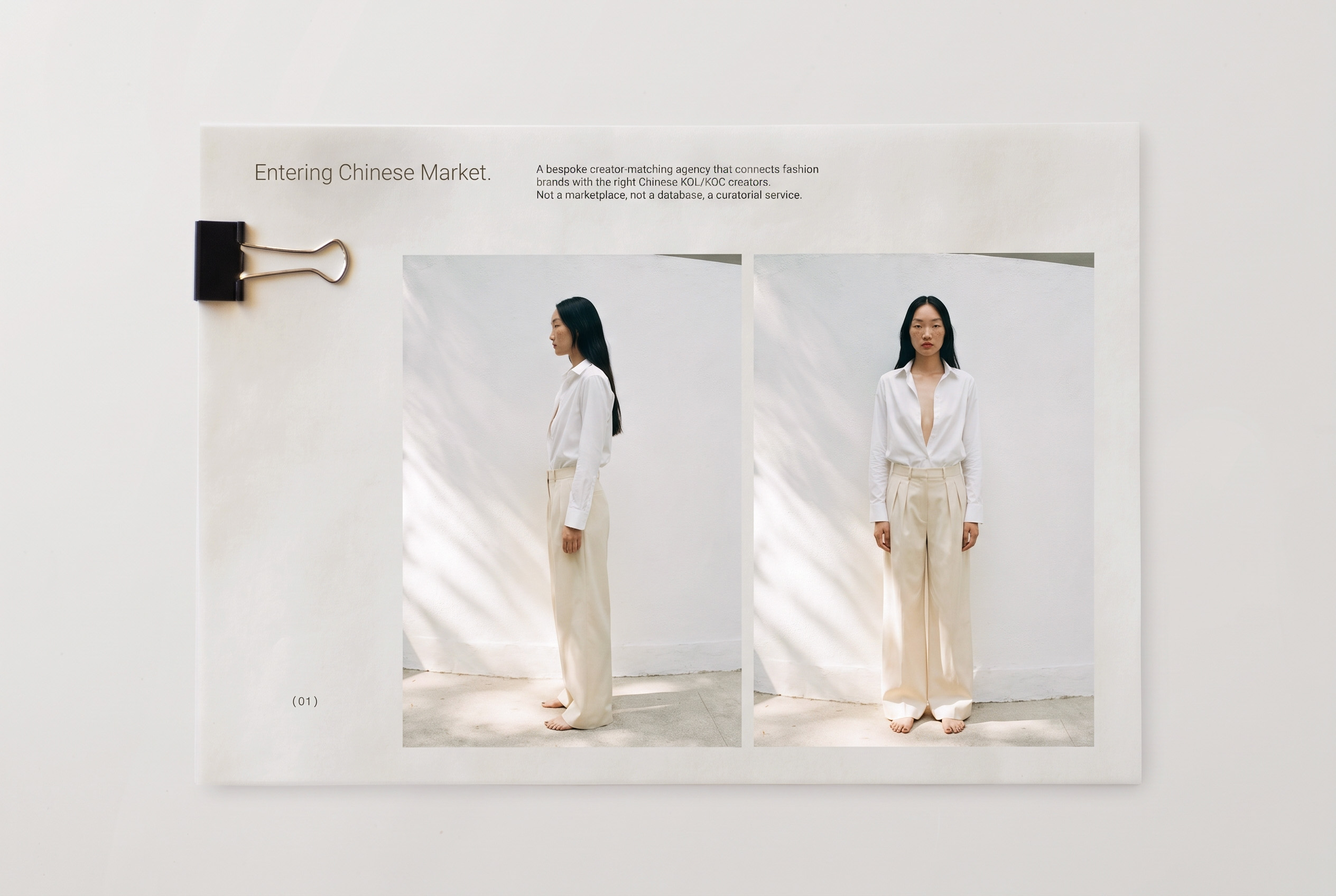 A printed page secured with a black binder clip on a white surface, featuring two photos of an Asian woman with long black hair wearing a white long-sleeve shirt and beige wide-leg pants, standing barefoot against a plain light wall, shown in profile and front views, with text about entering the Chinese market and describing a creator-matching agency connecting fashion brands with Chinese KOL/KOC creators.