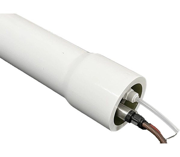 Close-up of the end of a white cylindrical device with electrical and clear tubing connections.