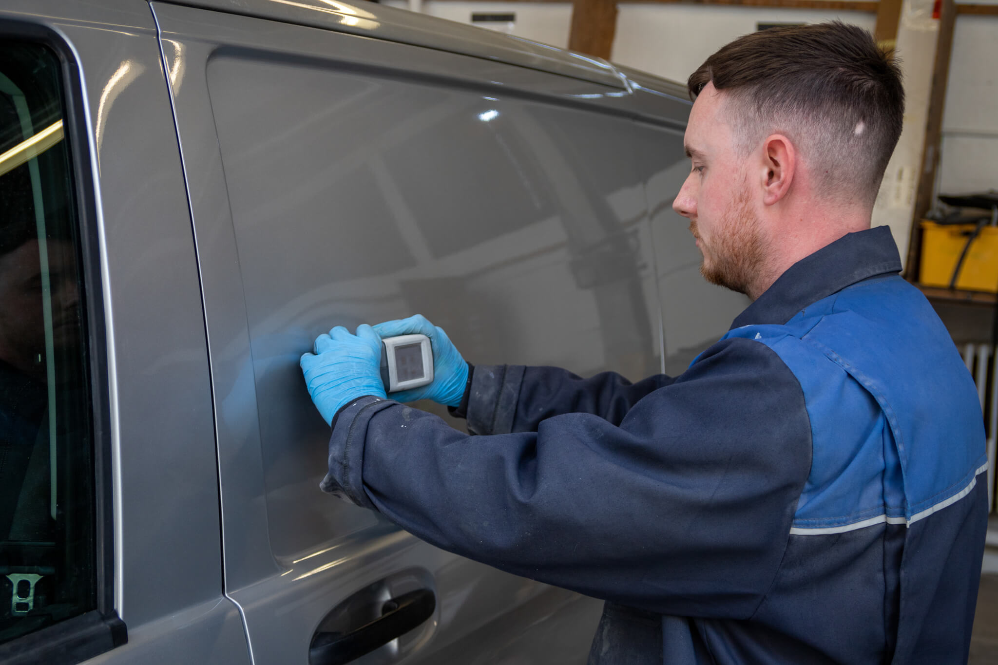 Vehicle repair technician testing the colour of a van