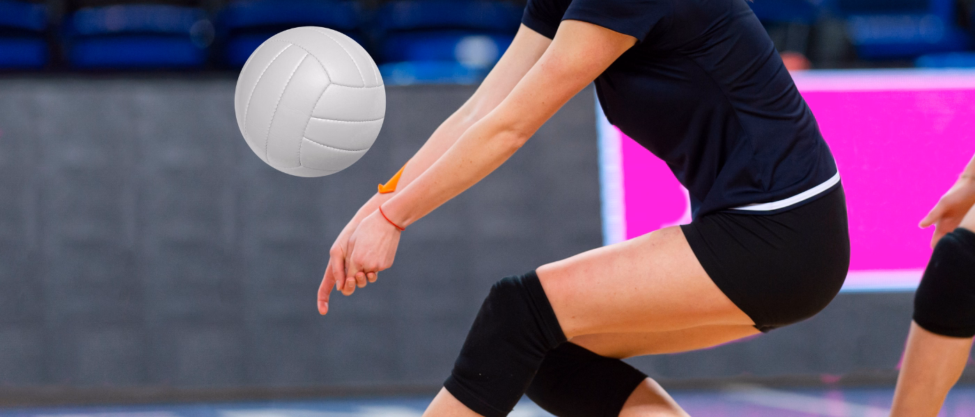Volleyball player in mid-game with bent knees and landing posture, highlighting common movement patterns that contribute to patellar tendinopathy or jumper’s knee.