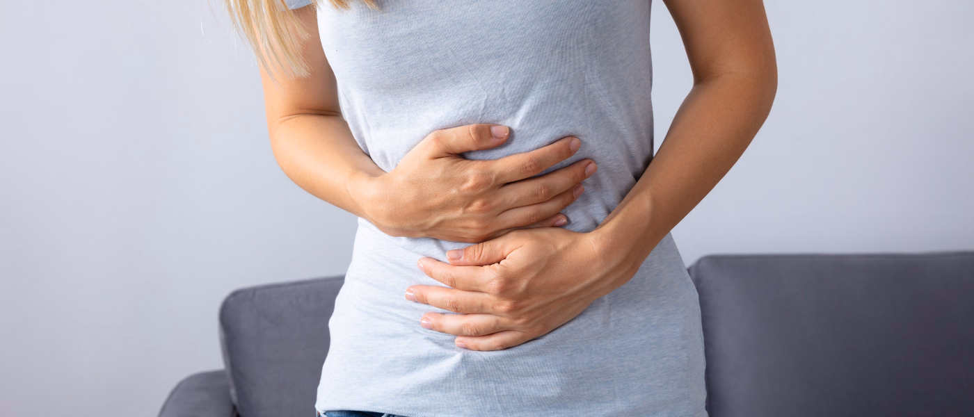 Woman holding lower abdomen illustrating chronic pelvic pain symptoms