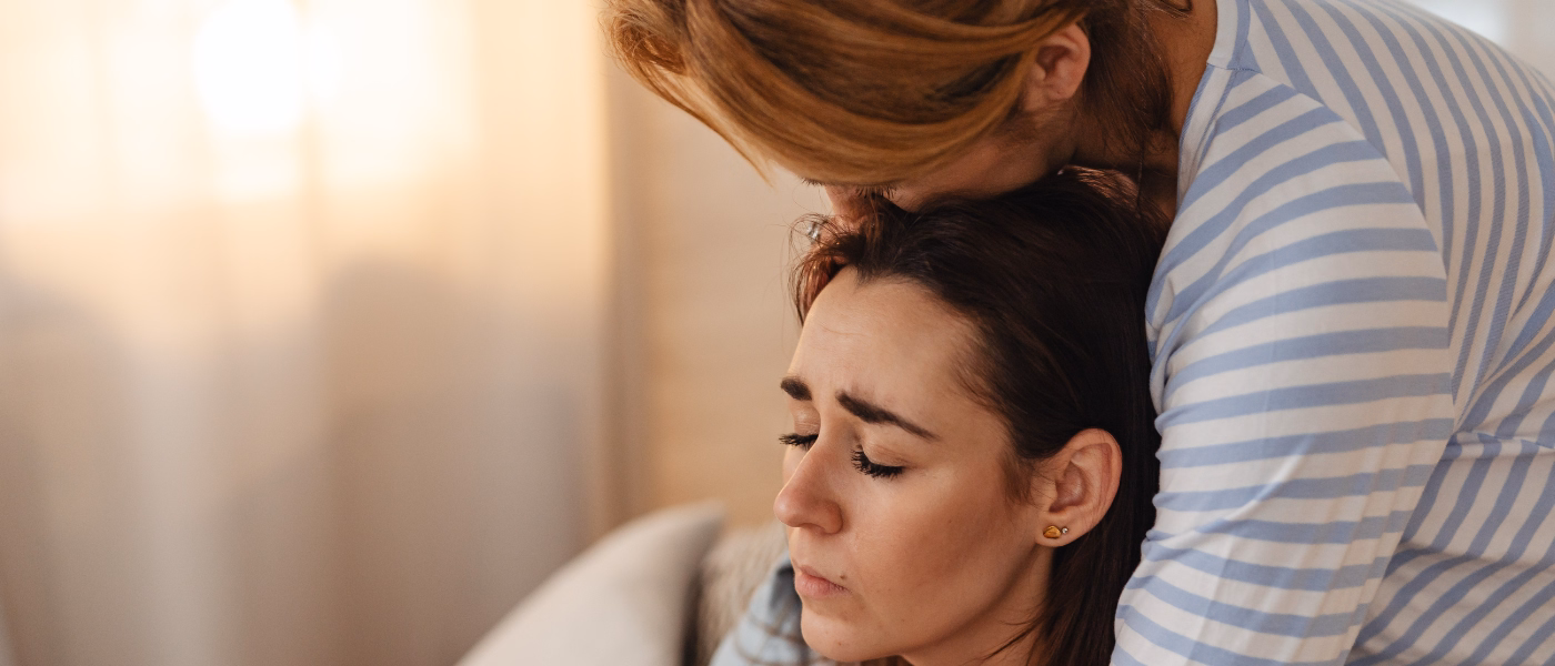 Woman being comforted illustrating the emotional impact of urinary incontinence