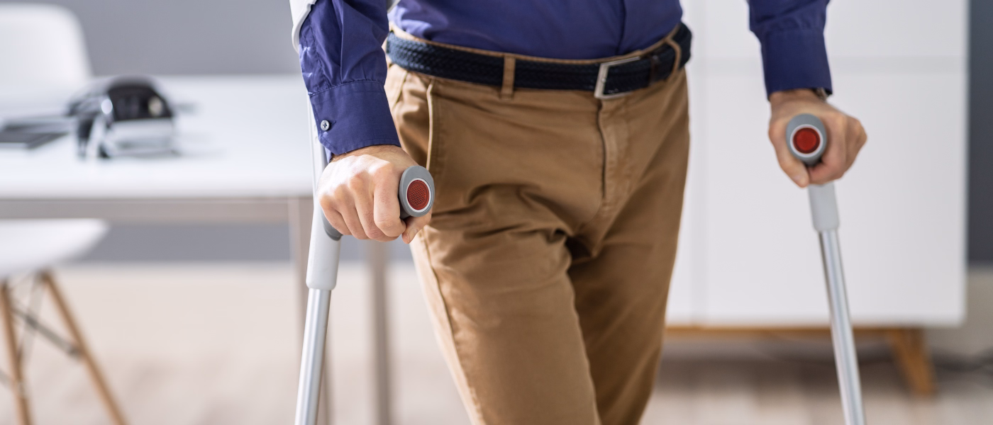 Patient using crutches during post surgical rehabilitation after lumbar fusion surgery
