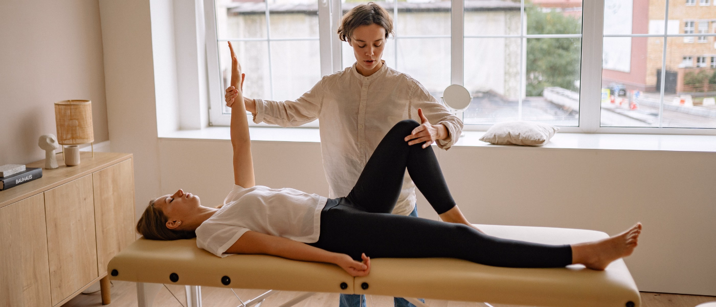 Physiotherapist assessing leg mobility during quadriceps strain or tear rehabilitation