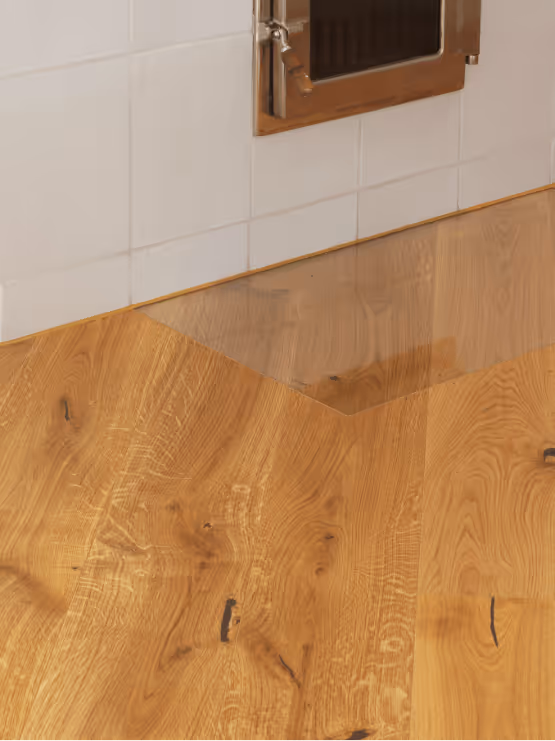 Detailfoto vor Kamin mit Glaseinsatz als Bodenschutz