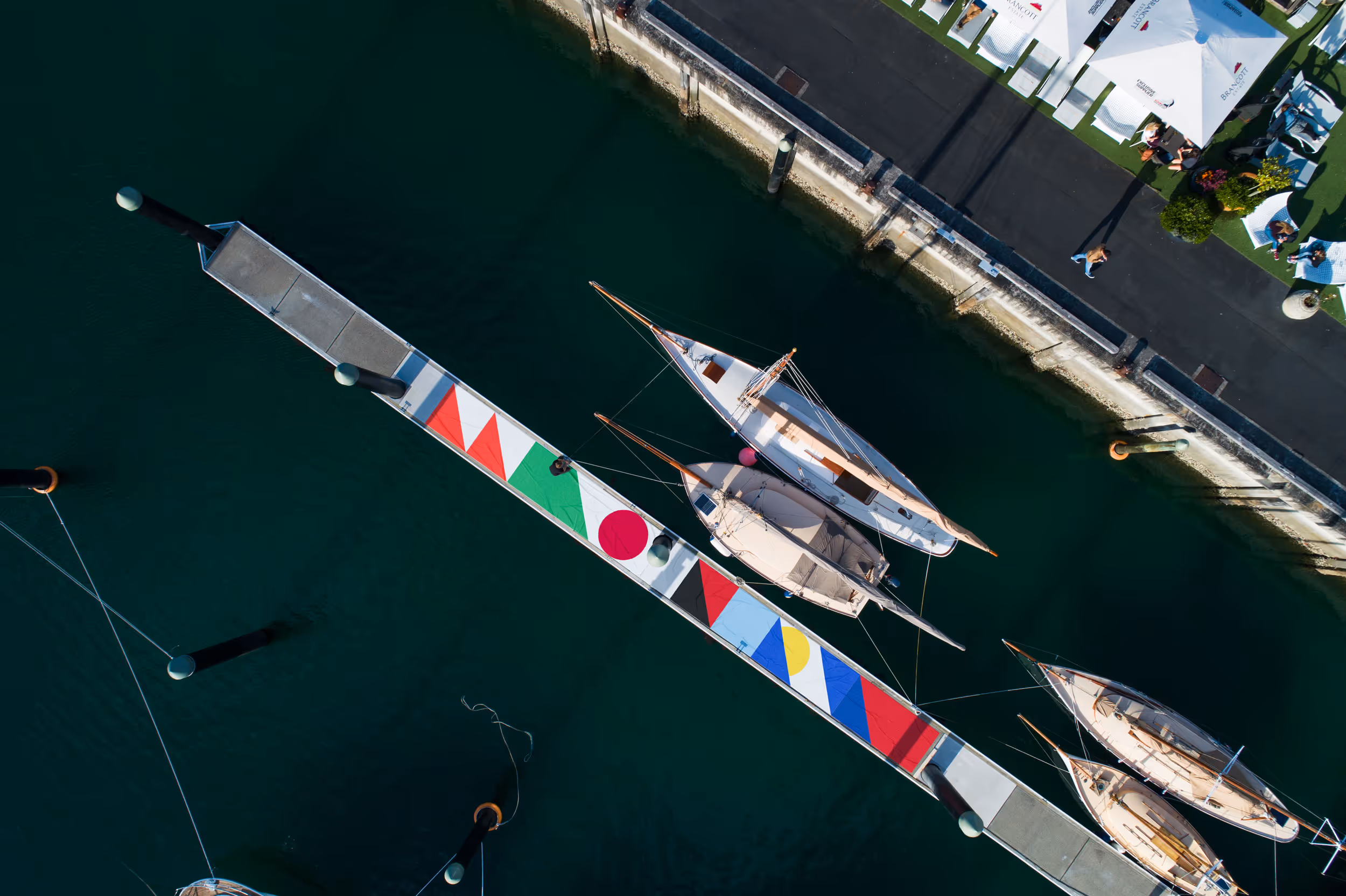 Aerial view of Rugby World Cup banners decorating a pier at Viaduct Harbour, with sailboats moored in the water