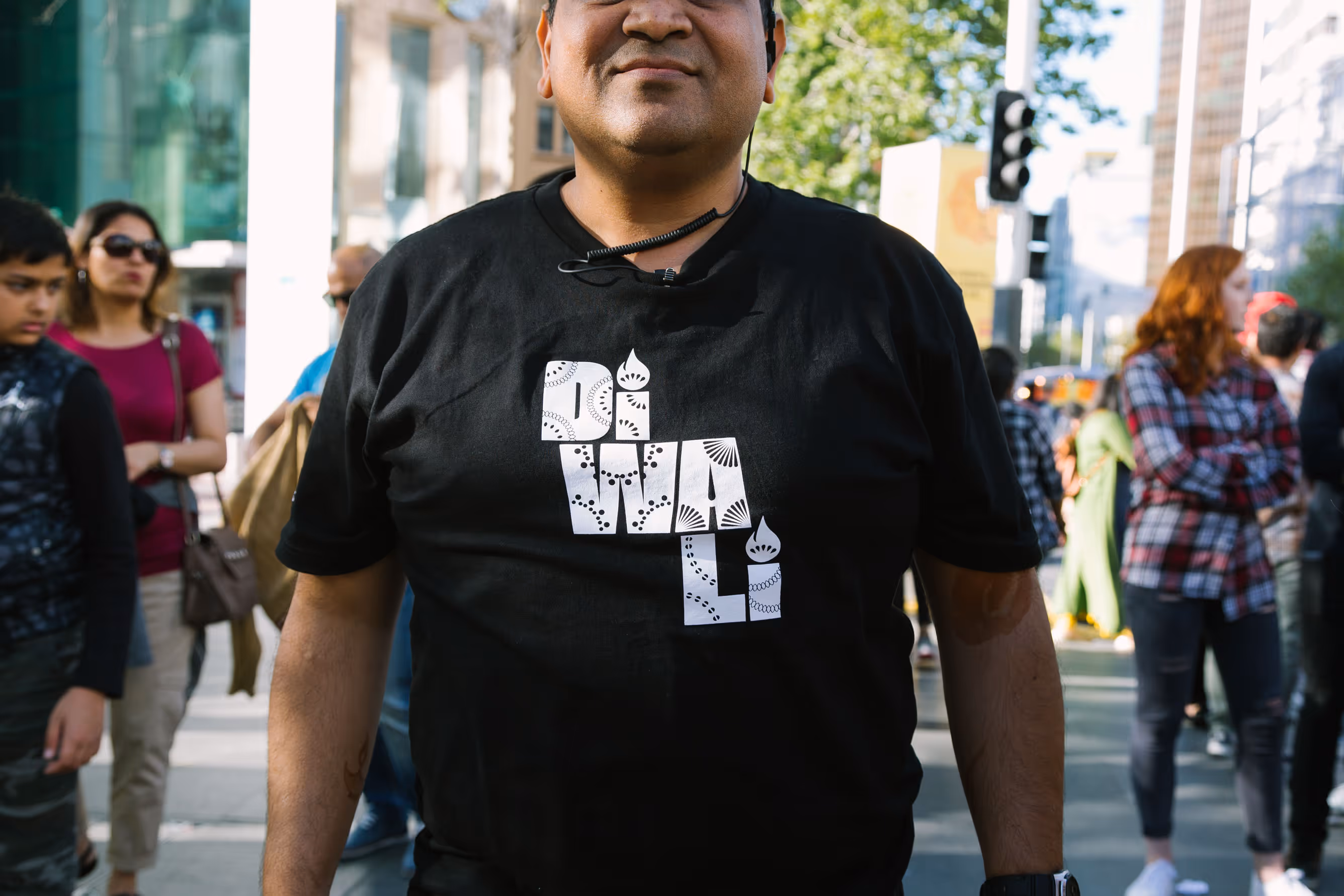 Person wearing a black t-shirt with the custom Diwali festival typography branding designed by Blink