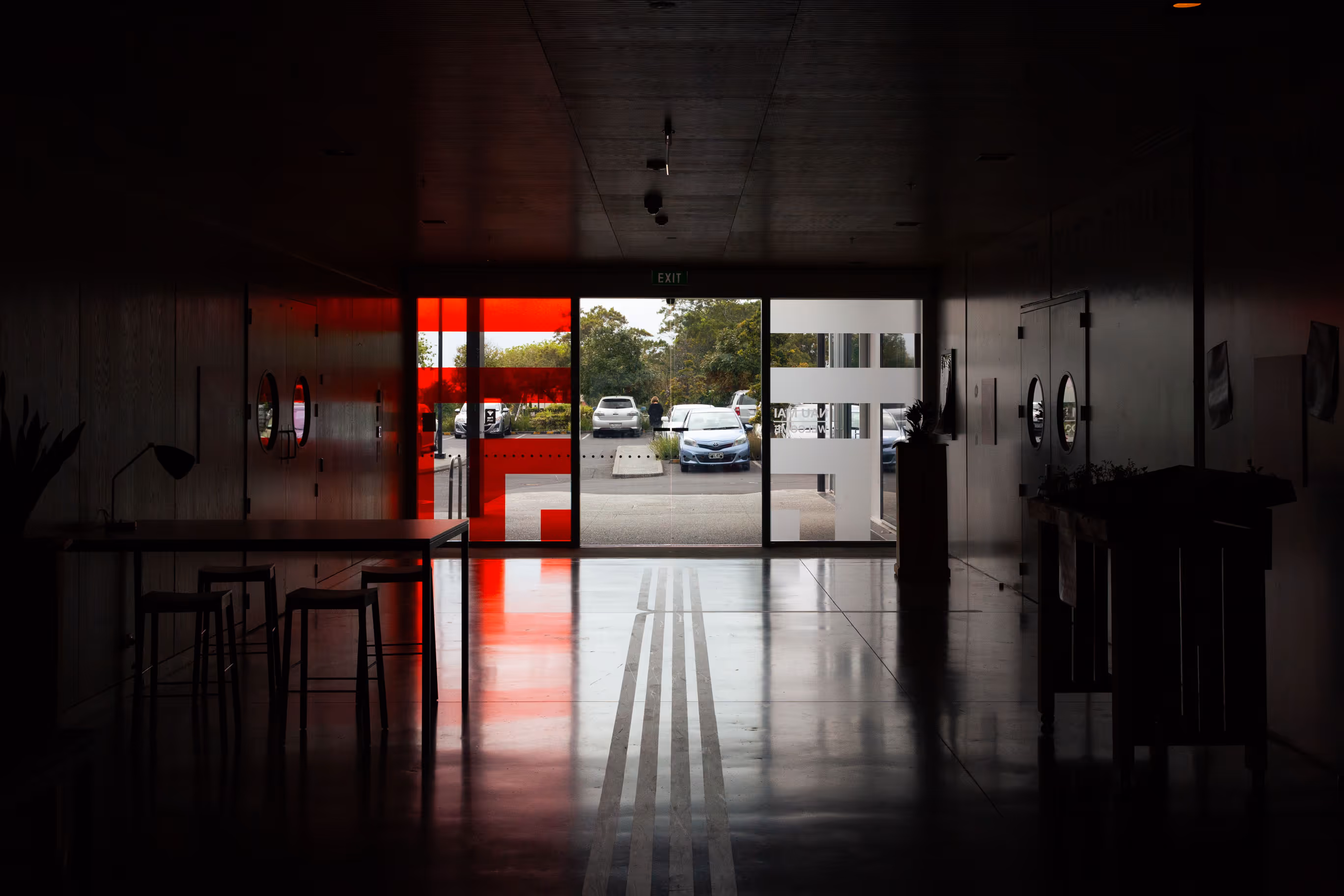Auckland Council community centre interior looking out through red and white window vinyl, designed, fabricated and installed by Blink, Auckland