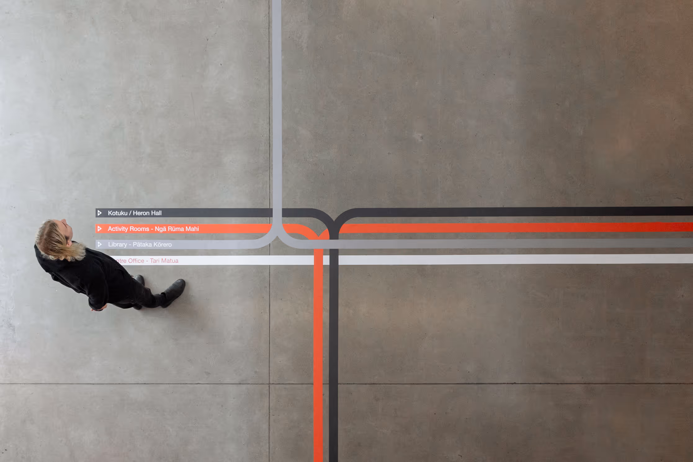 Auckland Council community centre floor wayfinding system with colour-coded vinyl lines in English and te reo Māori, designed, fabricated and installed by Blink, Auckland
