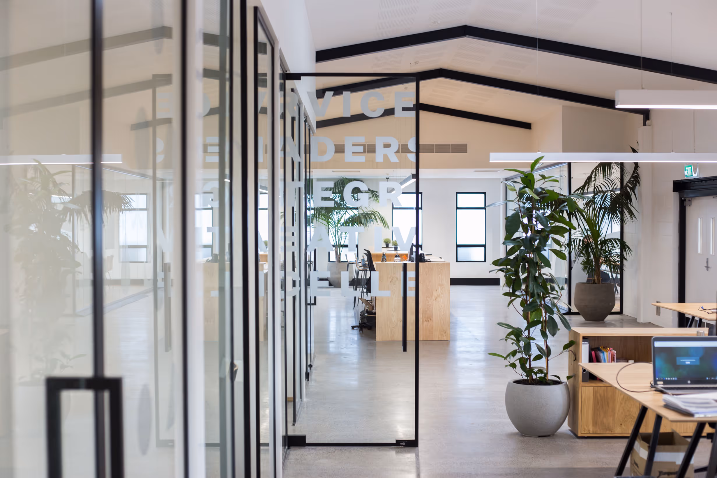 Custom white typographic decals on glass office doors for Collective workspace by Blink