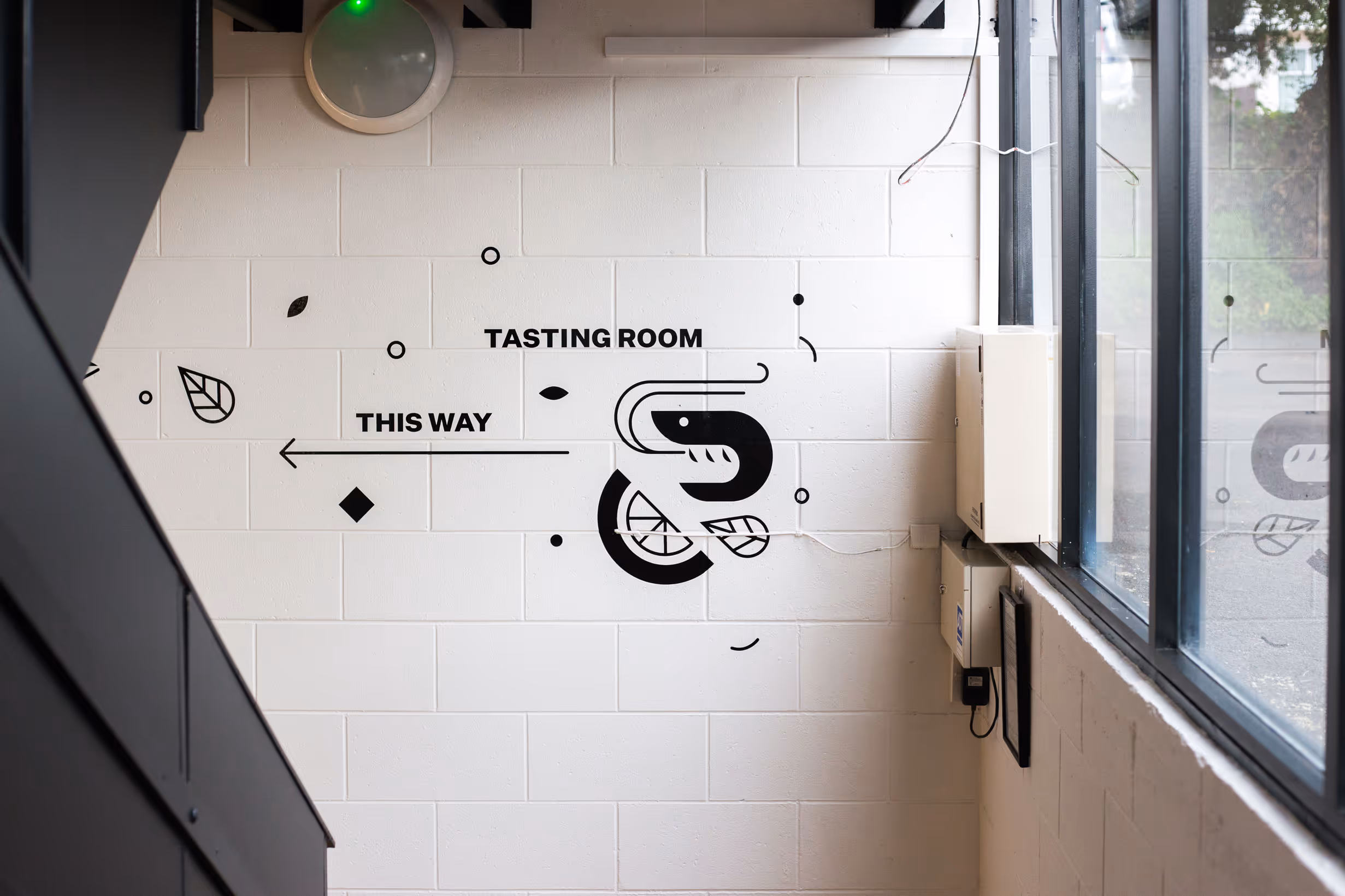 Custom black tasting room wayfinding wall graphics with abstract food iconography for Collective workspace by Blink