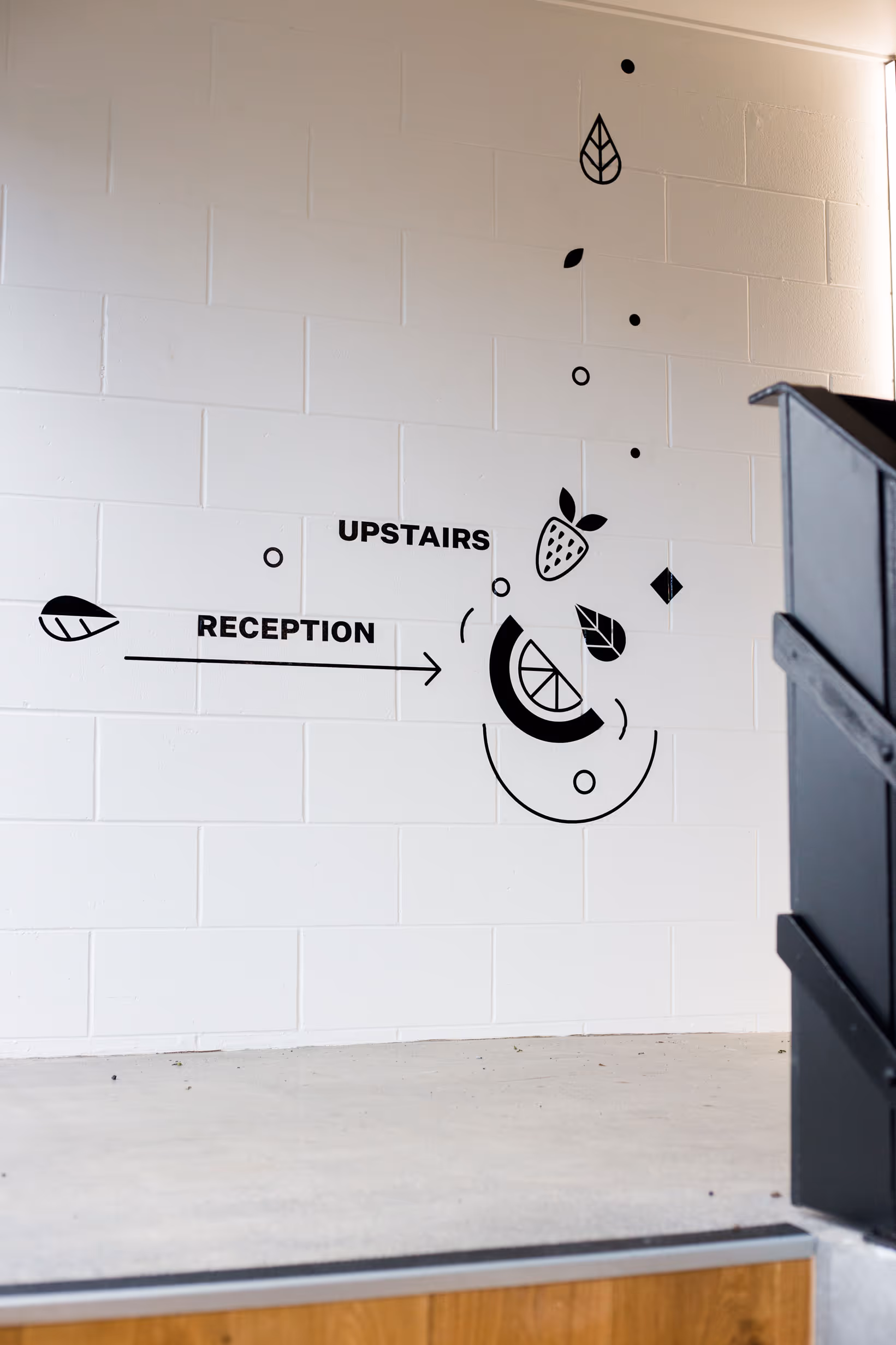 Custom black wayfinding wall graphics with abstract food iconography for Collective workspace by Blink