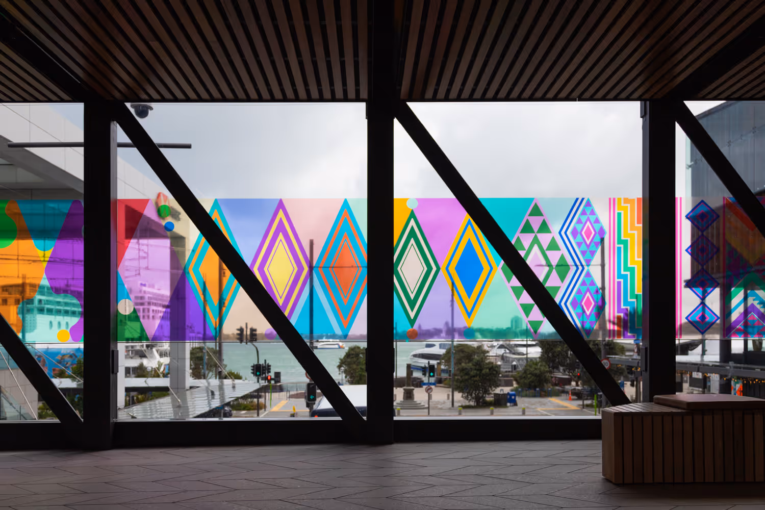 Colourful geometric window vinyl installation at Commercial Bay airbridge overlooking Auckland waterfront, designed, fabricated and installed by Blink, Auckland