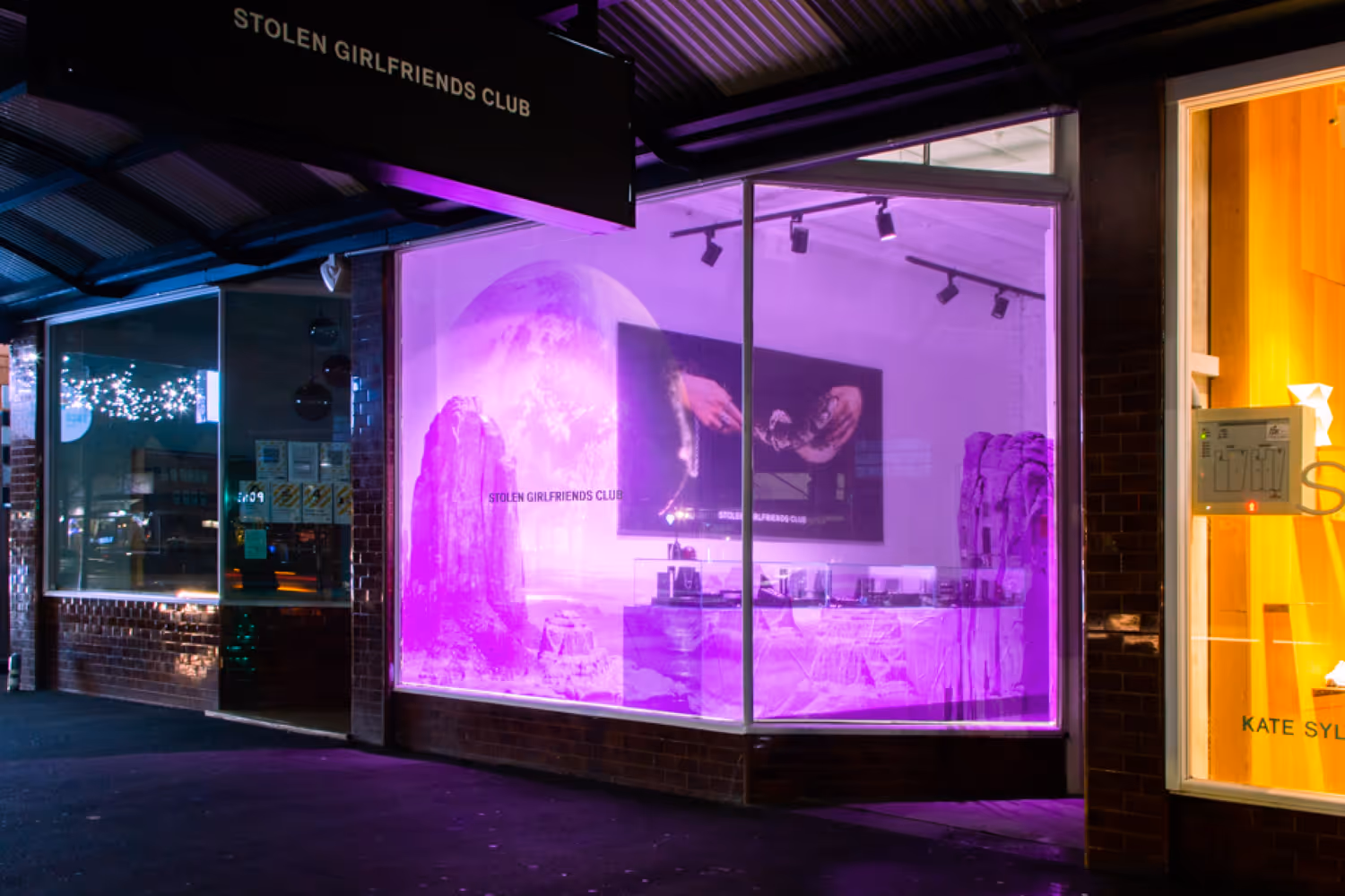 Stolen Girlfriends Club storefront on Ponsonby Road, featuring an illuminated purple window display
