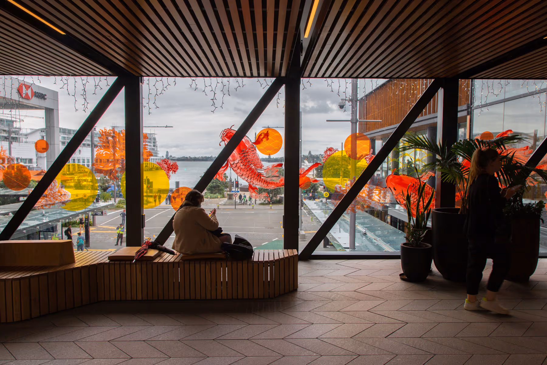 Pedestrian walkway at Commercial Bay featuring an installation of colourful koi fish graphics on windows